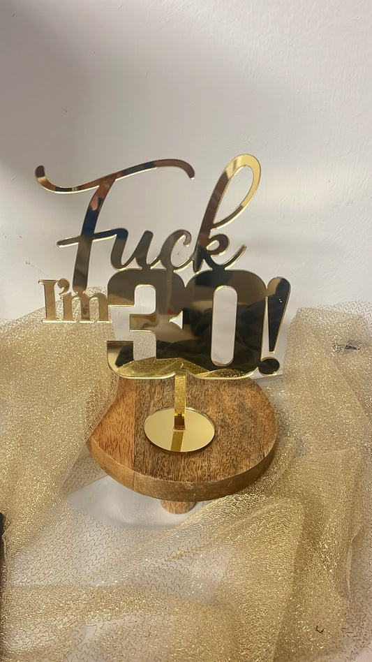 Cake topper Fuck I'm 30 en finition miroir doré, présenté sur un socle